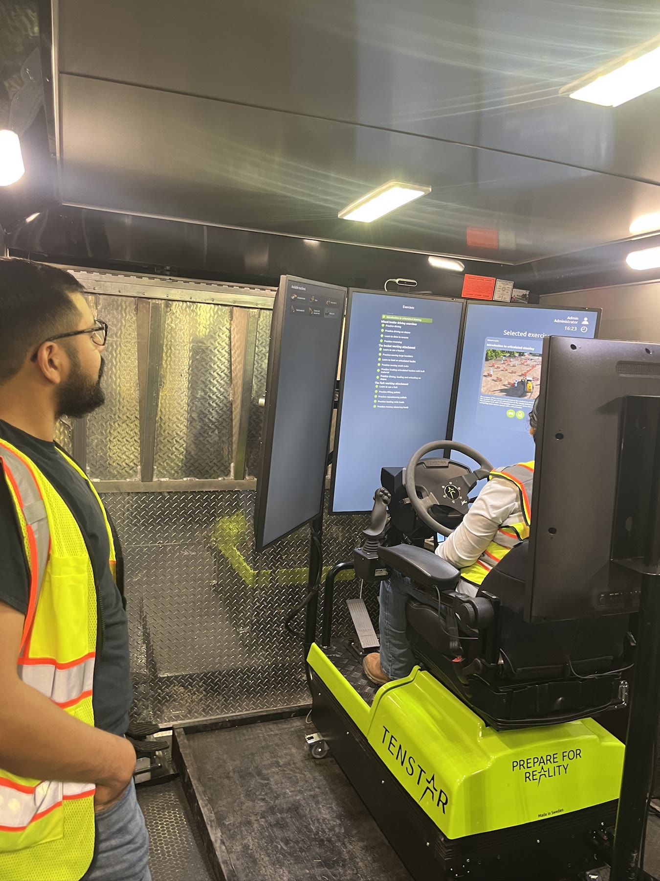 Instructor observing an operator during a guided heavy equipment simulator session
