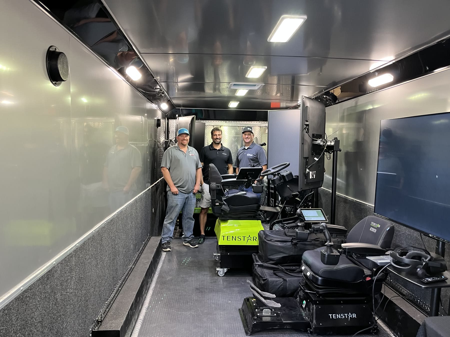 Three crew members inside the Collup Enterprises mobile simulator training trailer