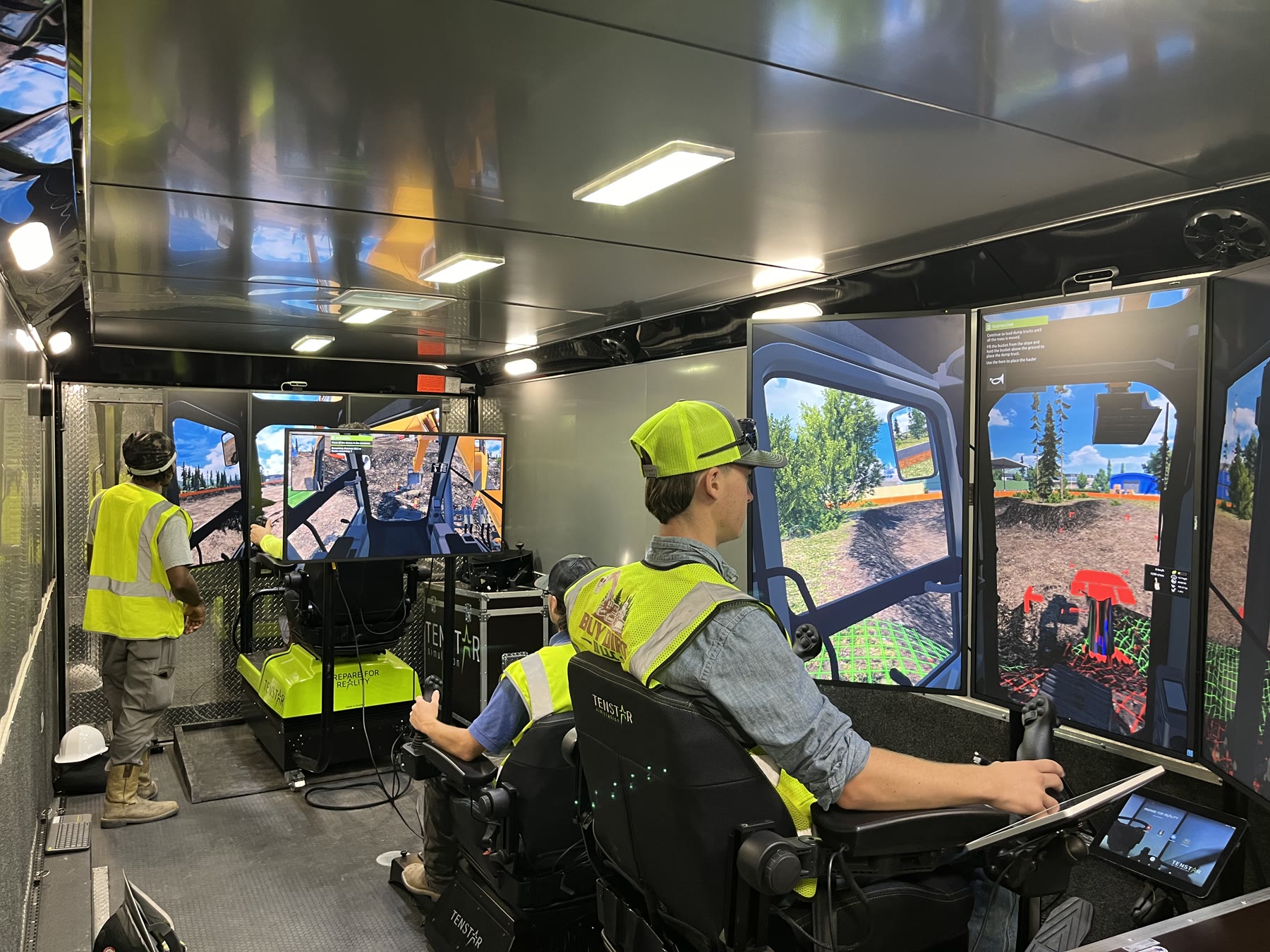 Three operators practicing simultaneously inside the Collup Enterprises mobile simulator trailer