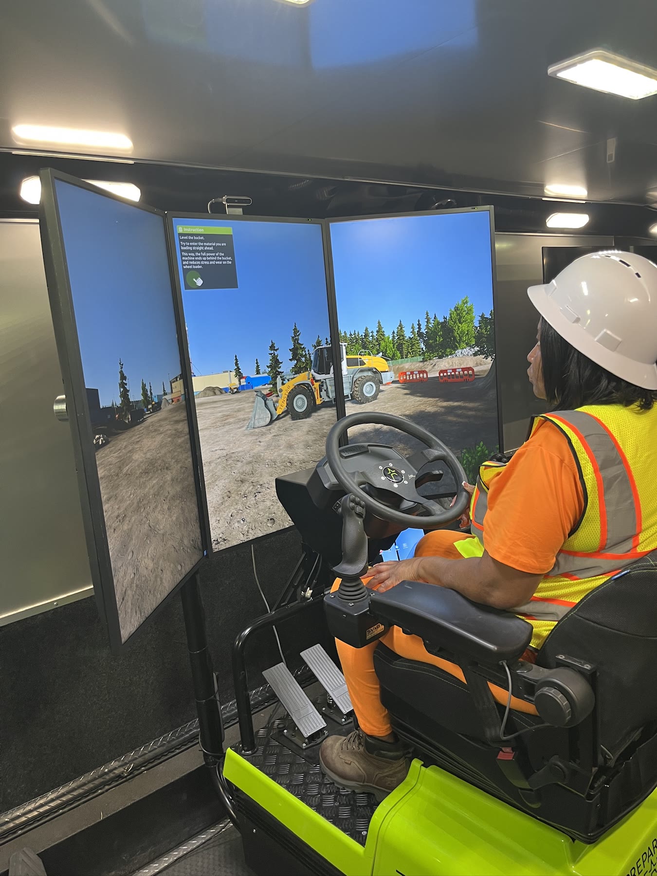 Operator practicing wheel loader controls in the mobile simulator training bay
